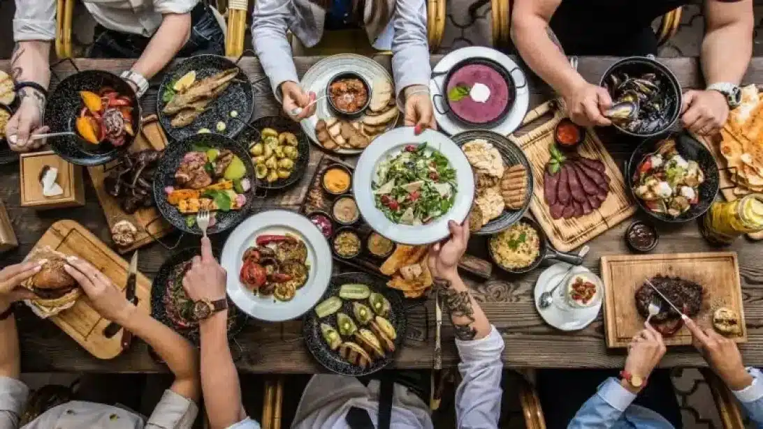 emberek faszenes grillen grilleznek a kertben