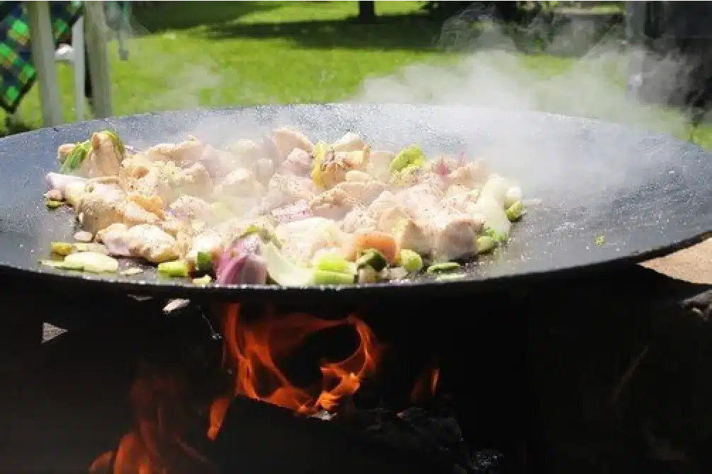 csirkehús sütése grillező tárcsán nyílt tűz felett