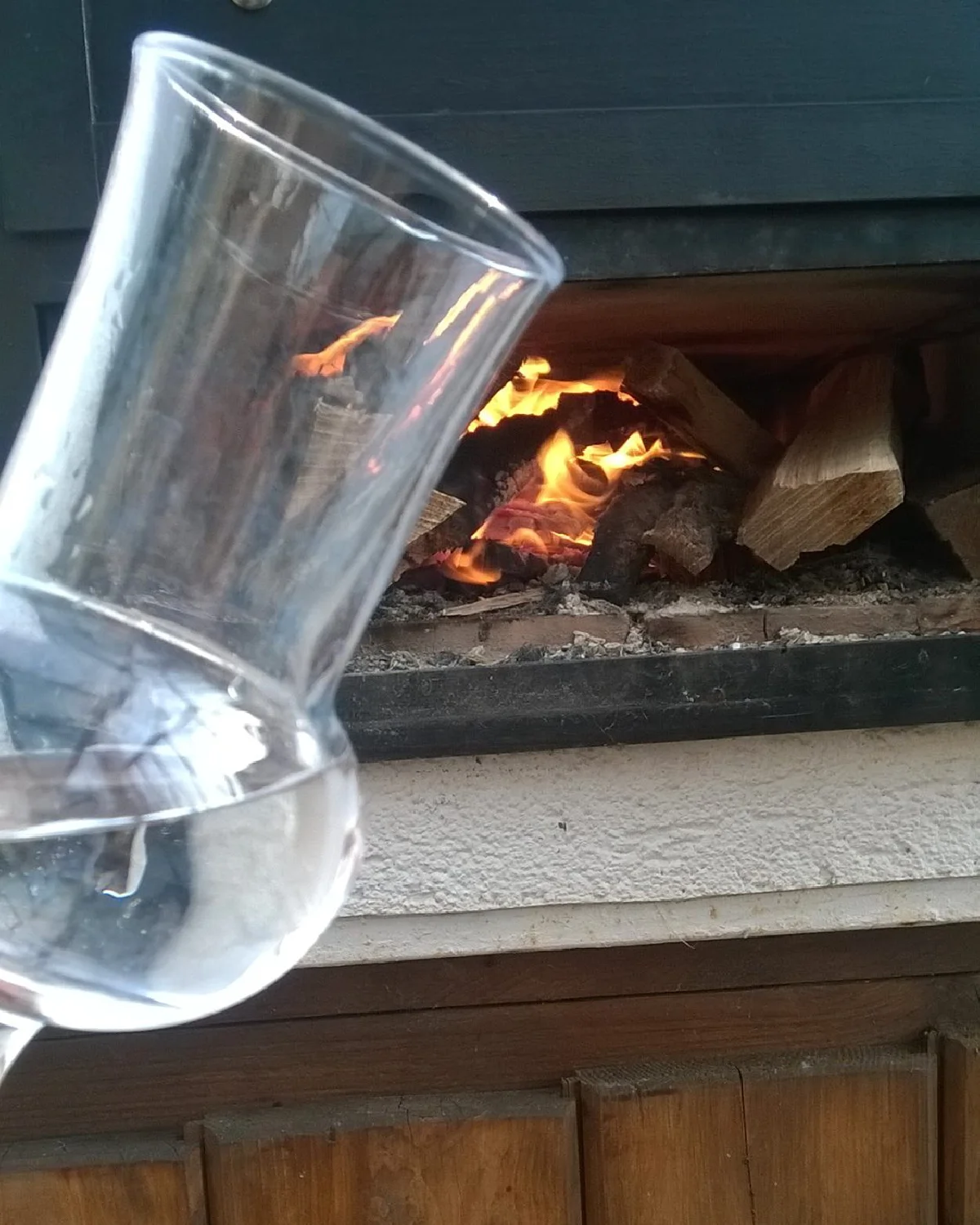 Hangulatos kerti jelenet fatüzelésű kemencével és stabil kéményrendszerrel